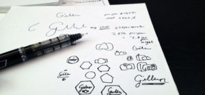 a pen and blank white paper covered in design doodles