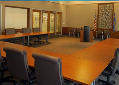an empty meeting room with desks arranged in a U shape facing a podium