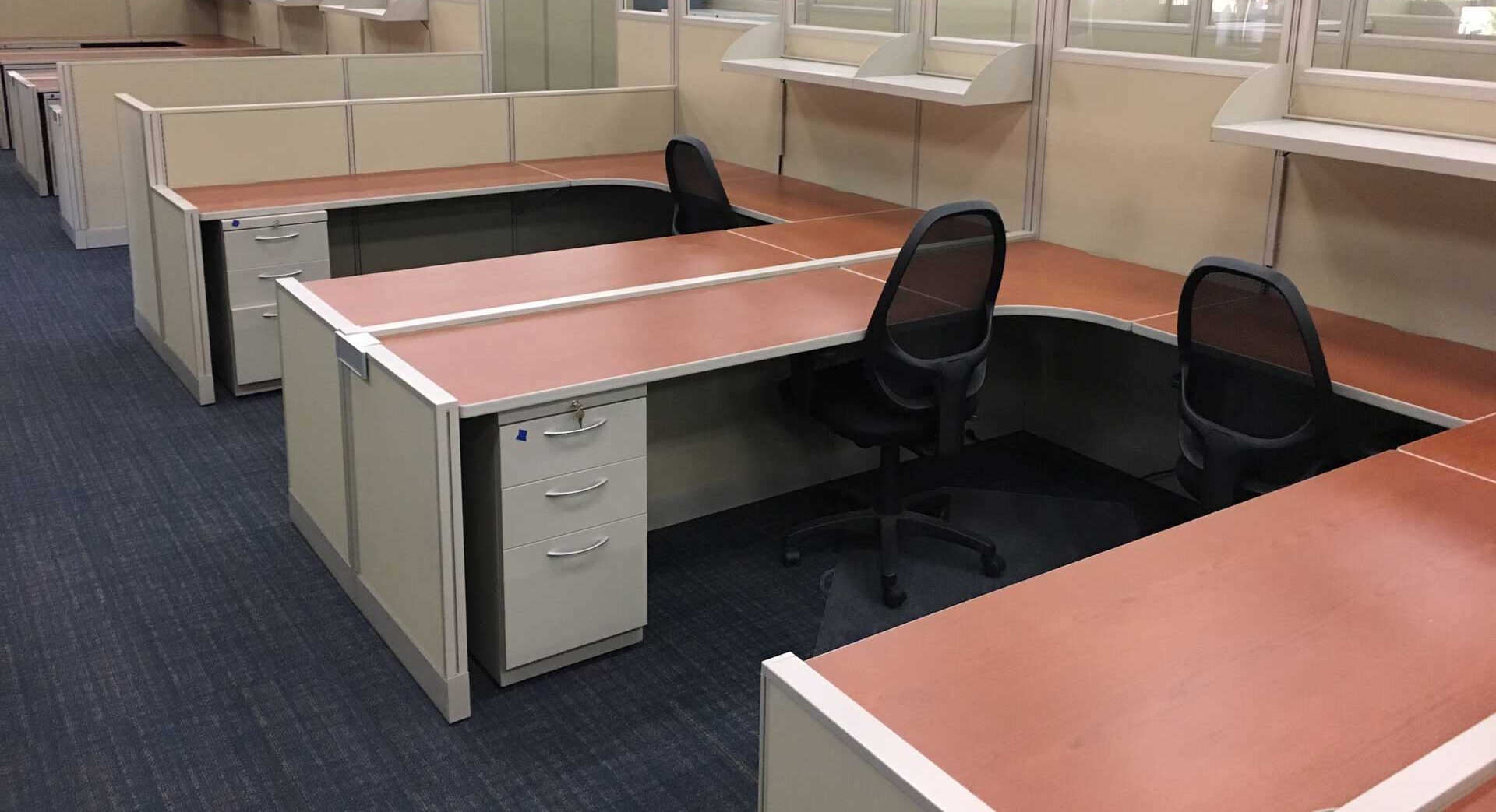 line of empty grey cubicles situated in an office